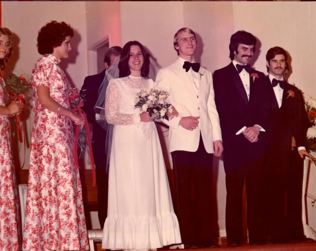 Wedding party with bride and groom smiling.