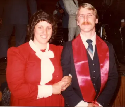 Two people posing in formal attire.
