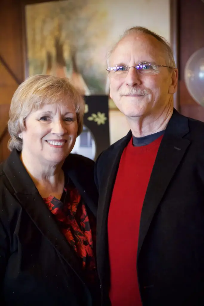 Smiling couple standing together indoors.