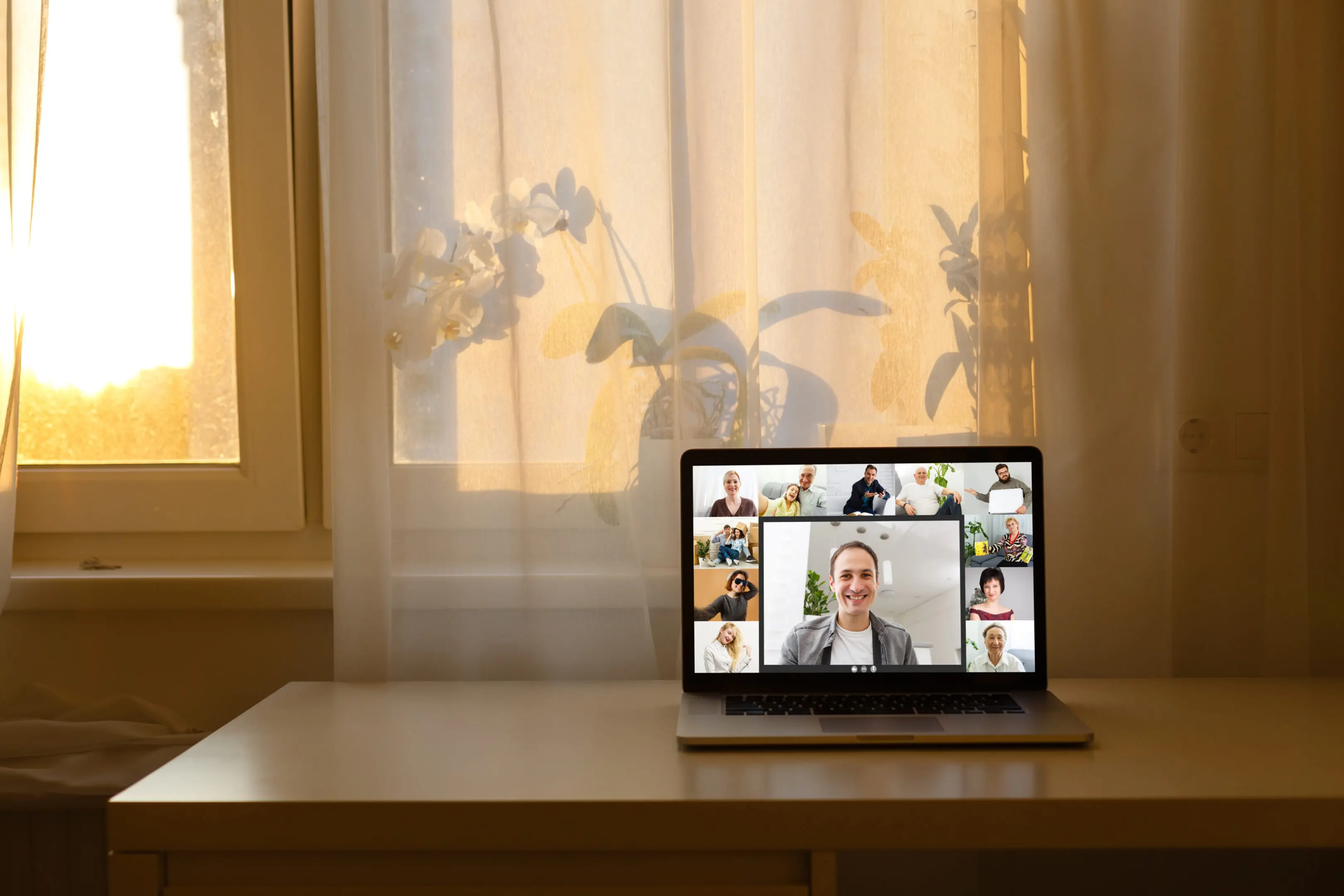 Laptop on desk with video call display.