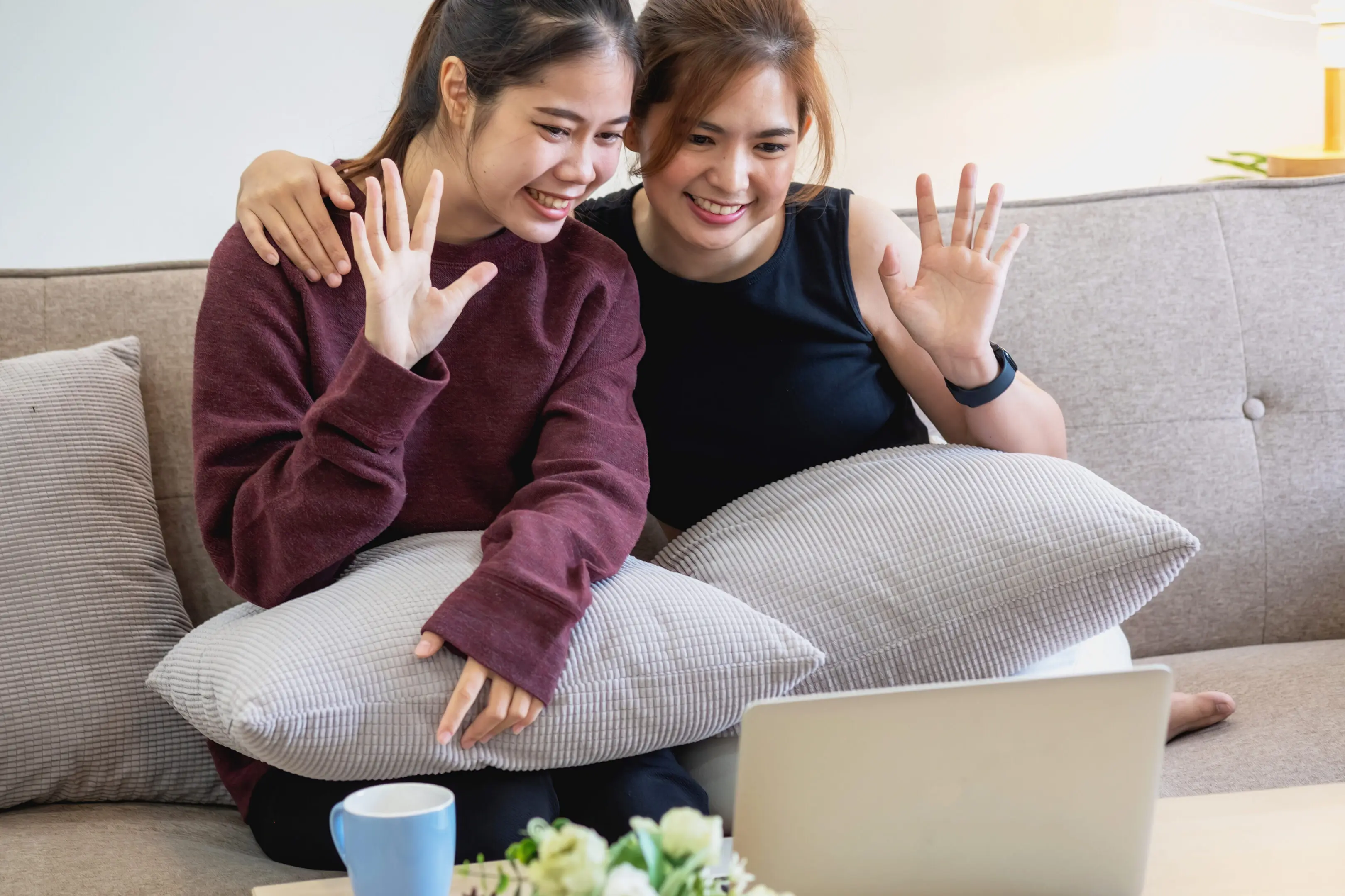 Two women waving during a video call.